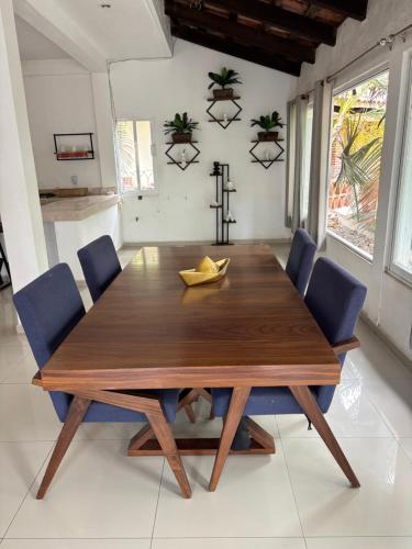 a wooden dining room table with blue chairs at Casa Gabriela in Bucerías