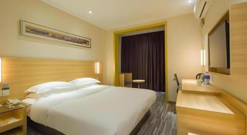 a large white bed in a hotel room at City Comfort Inn Wuhan Guanggu Textile University in Wuhan