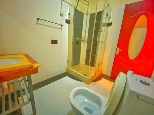 a bathroom with a toilet and a shower and a sink at Shanzu Oceanfront Apartments and Suites in Mombasa
