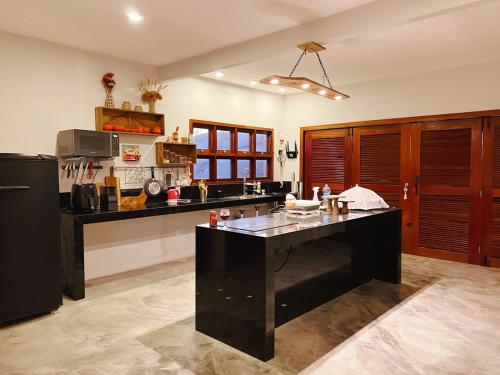 a kitchen with a black island in the middle at Casa Lajeiro in Serra de São Bento