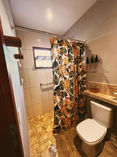 a bathroom with a toilet and a shower curtain at Casa Lajeiro in Serra de São Bento