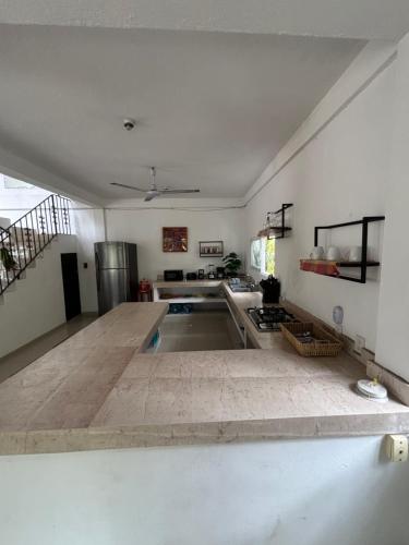 a large kitchen with a sink in the middle at Casa Gabriela in Bucerías