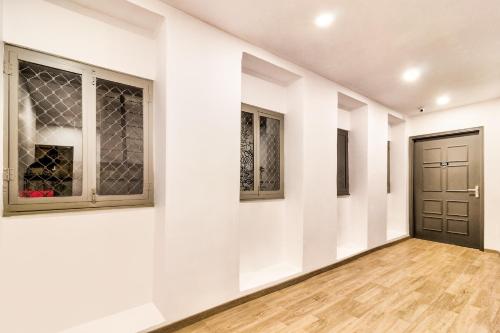 a hallway with white walls and a door at Hotel O Akash Ganga Park Circus in Ballygunge