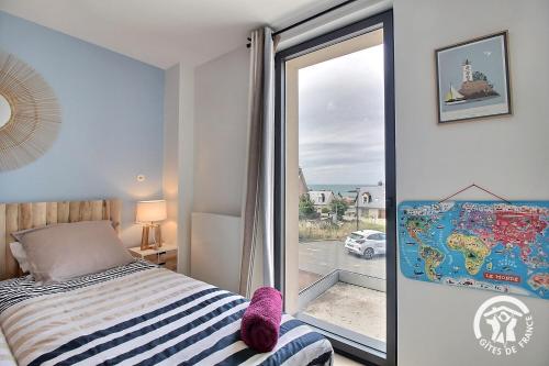 a bedroom with a bed and a window with a view at Les belles vues d'erquy in Erquy