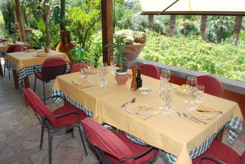 a table in a restaurant with red chairs and a table with glasses at Residence Villa Cristina in Ischia