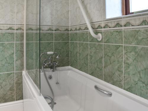 a bathroom with a bath tub with a shower at Gwel An Lowarth in Lostwithiel