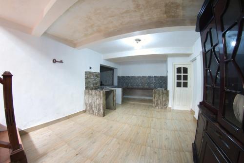 an empty living room with white walls and wooden floors at Bee Hive Villa Kandy in Kandy
