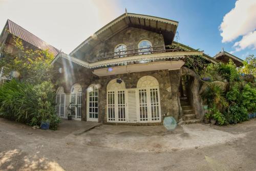 a stone house with a balcony on top of it at Bee Hive Villa Kandy in Kandy