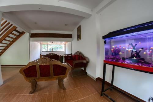 a living room with a large aquarium in the corner at Bee Hive Villa Kandy in Kandy