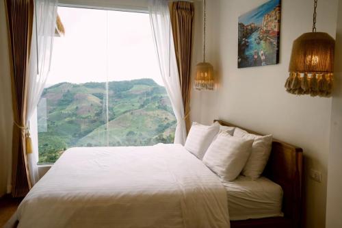 a bedroom with a bed and a large window at Nontawa Villa Doichang in Ban Huai Khai