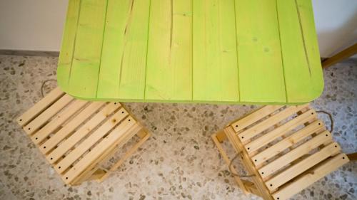 a green table with two wooden chairs under it at Casa della Nonna Polignano a mare in Polignano a Mare