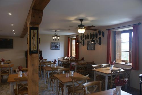 a restaurant with wooden tables and chairs in a room at Hotel Colonial de Santillana in Santillana del Mar