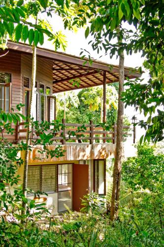 a house with a wooden deck in the woods at Chestnut Hill Eco Resort Hat Yai in Hat Yai