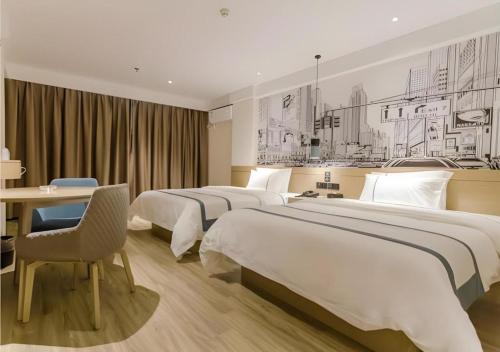 een hotelkamer met 2 bedden, een tafel en een bureau bij City Comfort Inn Zhaoqing Sihui Nanjiang Industrial Park in Xiahuangtang