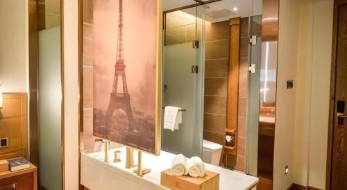 a bathroom with a sink and a mirror with the eiffel tower at James Joyce Coffetel Luoyang Longmen High-speed Railway Station Baolong Plaza in Luoyang
