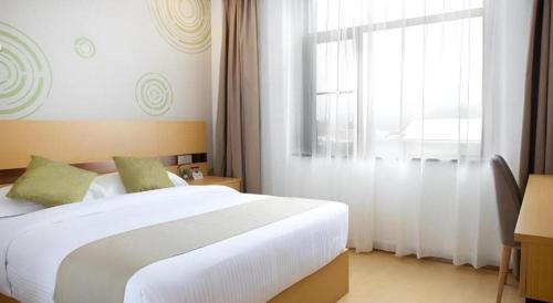 a bedroom with a large white bed and a window at GreenTree Inn Linhai Jiangnan Avenue Express in Linhai