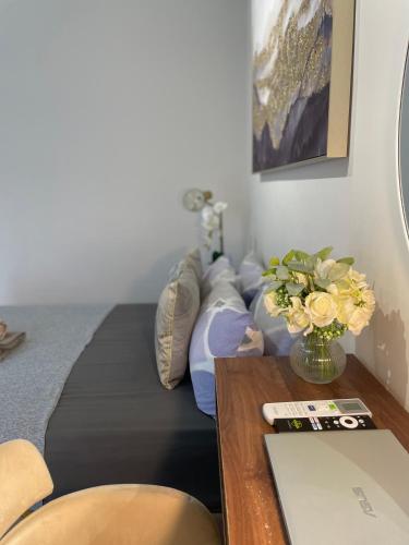 a bedroom with a bed and a table with a vase of flowers at The Suite Room at The Amani Grand in Mactan Cebu International