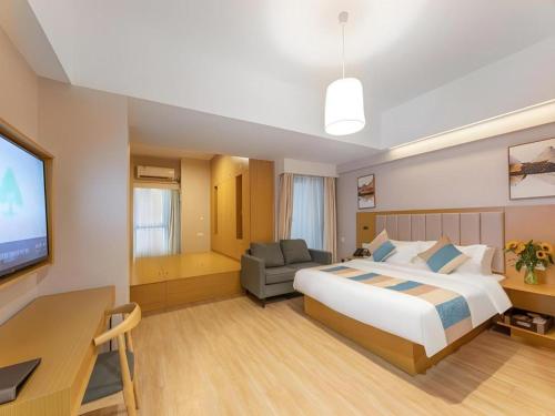 a hotel room with a bed and a desk and a tv at VX Hotel Wuxi Xinwu District Executive Center Wanda Plaza in Wuxi