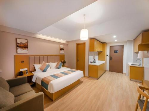 a hotel room with a bed and a couch at VX Hotel Wuxi Xinwu District Executive Center Wanda Plaza in Wuxi