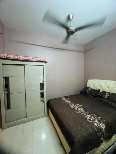 a bedroom with a bed and a ceiling fan at FS Homestay Jitra in Jitra