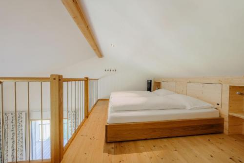 a bed in a room with a wooden floor at Landhaus Valfontana in Vandans