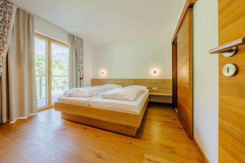 a bedroom with a bed and a large window at Landhaus Valfontana in Vandans