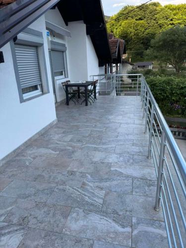 a stone patio with a table on a balcony at Apartman Studio EMA in Orašac