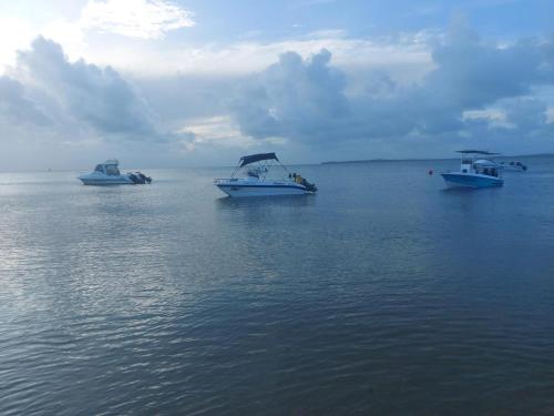 three boats floating in the water on the ocean at Nhucha Villas in Santa Maria