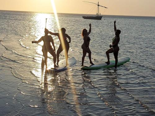 a group of people on surfboards in the water at Nhucha Villas in Santa Maria