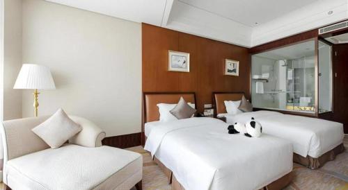 a hotel room with two beds with a panda bear on the bed at Balan International Hotel in Dujiangyan