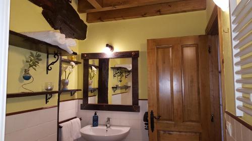 a bathroom with a sink and a mirror at Apartamentos La Plazuela in Quintana de Soba