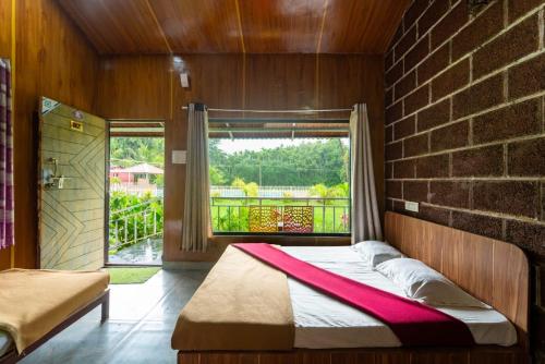 ein Schlafzimmer mit einem Bett und einer Ziegelwand in der Unterkunft New Wind Stay in Dandeli