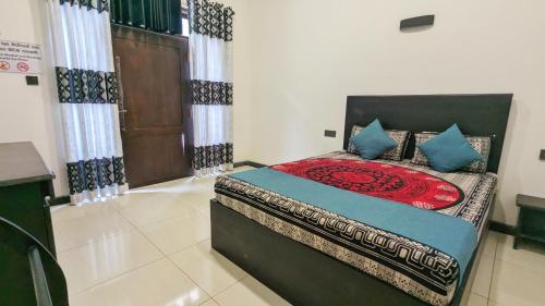 a bedroom with a bed with blue pillows at The Village - Ella in Bandarawela