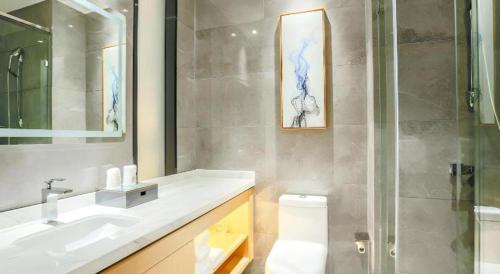 une salle de bain avec toilettes, lavabo et douche dans l'établissement City Comfort Inn Yidu Three Gorges Qianguqing Wanda Plaza, à Yichang