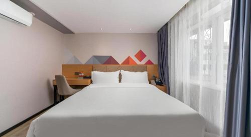 ein Schlafzimmer mit einem großen weißen Bett und einem Fenster in der Unterkunft Borrman Hotel Guangzhou Shisanhang Ximenkou Metro Station in Guangzhou