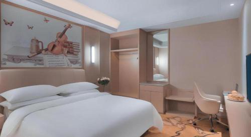 a bedroom with a large white bed and a desk at Vienna Hotel Zhejiang Tongxiang Puyuan in Jiaxing