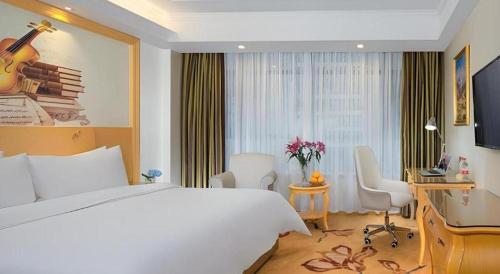a hotel room with a bed and a desk at Vienna Hotel Guangdong Zhaoqing Sihui Tianguangxu in Zhaoqing