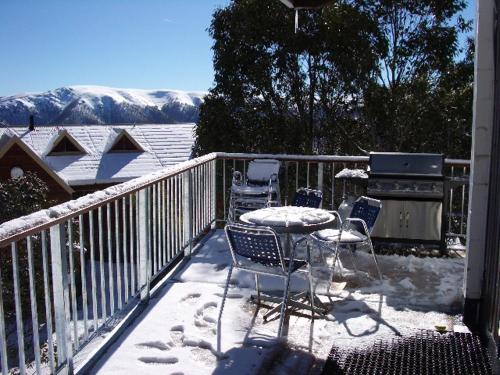 a balcony with chairs and a table in the snow at Sun Valley Apartment 7 in Falls Creek