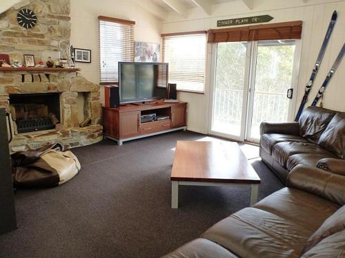 a living room with a couch and a television at Sun Valley Apartment 7 in Falls Creek