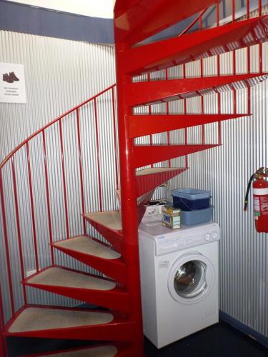 a red staircase in a laundry room with a washing machine at Sun Valley Apartment 7 in Falls Creek