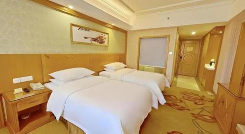 a hotel room with two beds and a bathroom at Vienna Hotel Guangxi Guilin Xing'an in Guilin