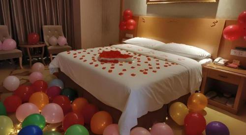 a room with a bed with balloons around it at Vienna Hotel Guangxi Guilin Xing'an in Guilin