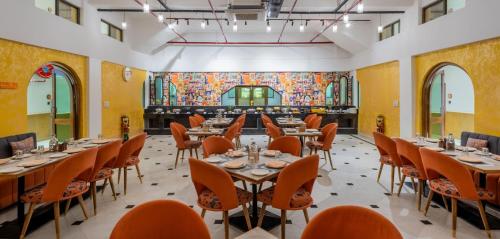 een rij tafels in een kamer met oranje stoelen bij Zone Connect by The Park Jaisalmer in Jaisalmer