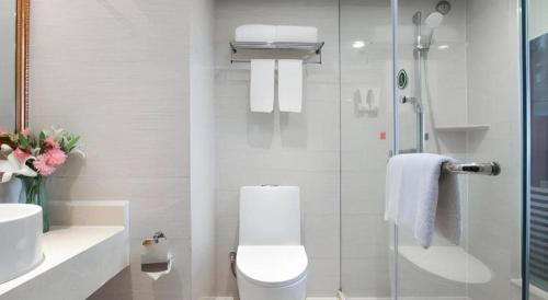 a bathroom with a toilet and a glass shower at Vienna Hotel Anhui Fuyang Yingshang Yingbin Avenue in Fuyang