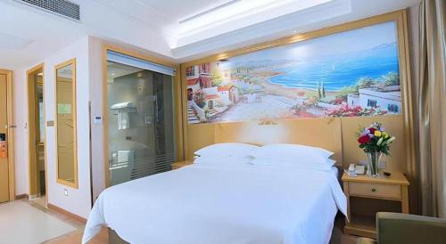 Ένα ή περισσότερα κρεβάτια σε δωμάτιο στο Vienna Hotel Hubei Xiangyang Tang City Gulou