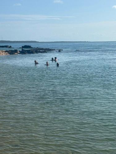 a group of people swimming in a body of water at Nhucha Villas in Santa Maria