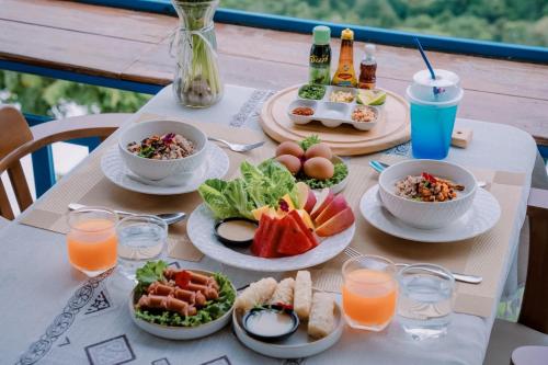 a table with plates of food and drinks on it at Nontawa Villa Doichang in Ban Huai Khai