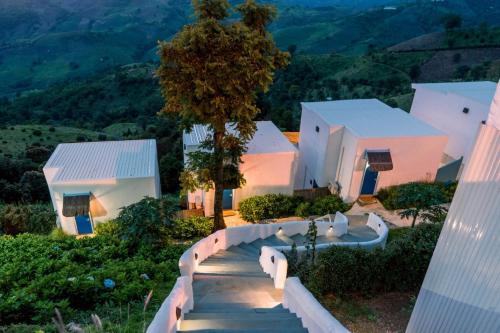 a house with a staircase leading up to a house at Nontawa Villa Doichang in Ban Huai Khai