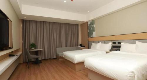 a hotel room with two beds and a flat screen tv at Green Tree Inn Yecheng County Zero Kilometer in Yecheng