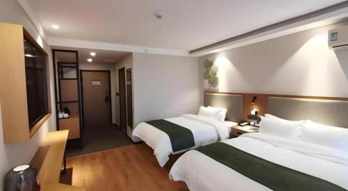 a hotel room with two beds and a television at Green Tree Inn Luoyang Fenghuang Mansion Mudan Square Metro Station in Luoyang
